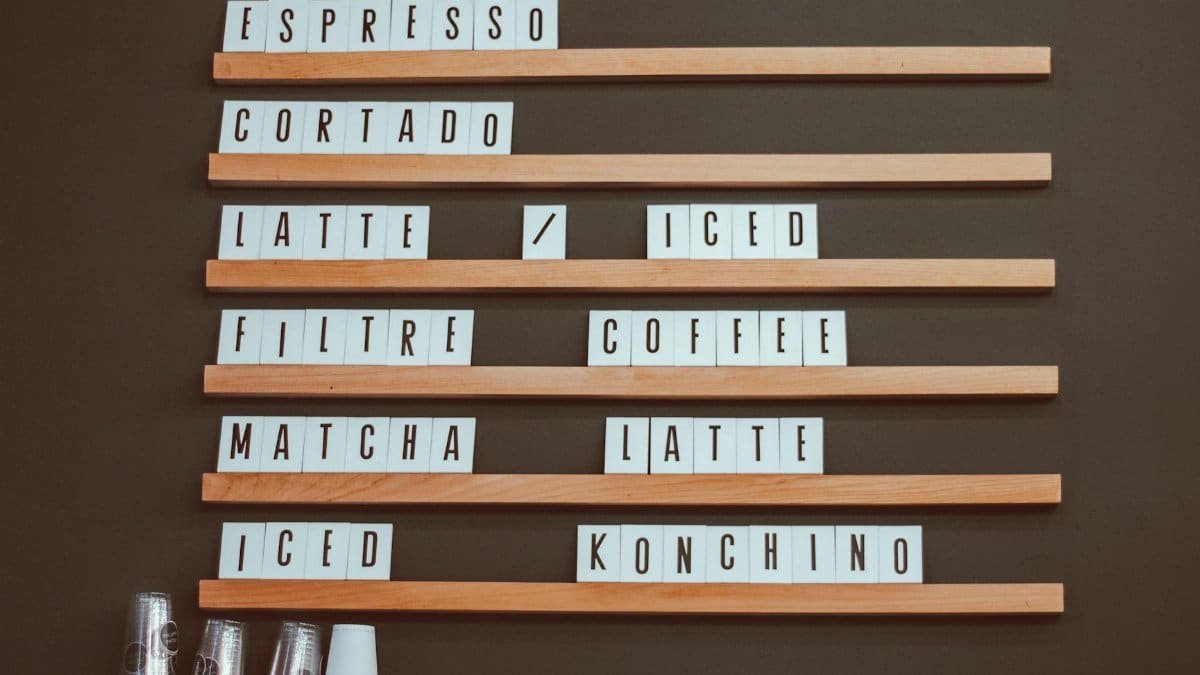Stylish coffee shop menu board with coffee options like espresso and latte in a cafe setting.