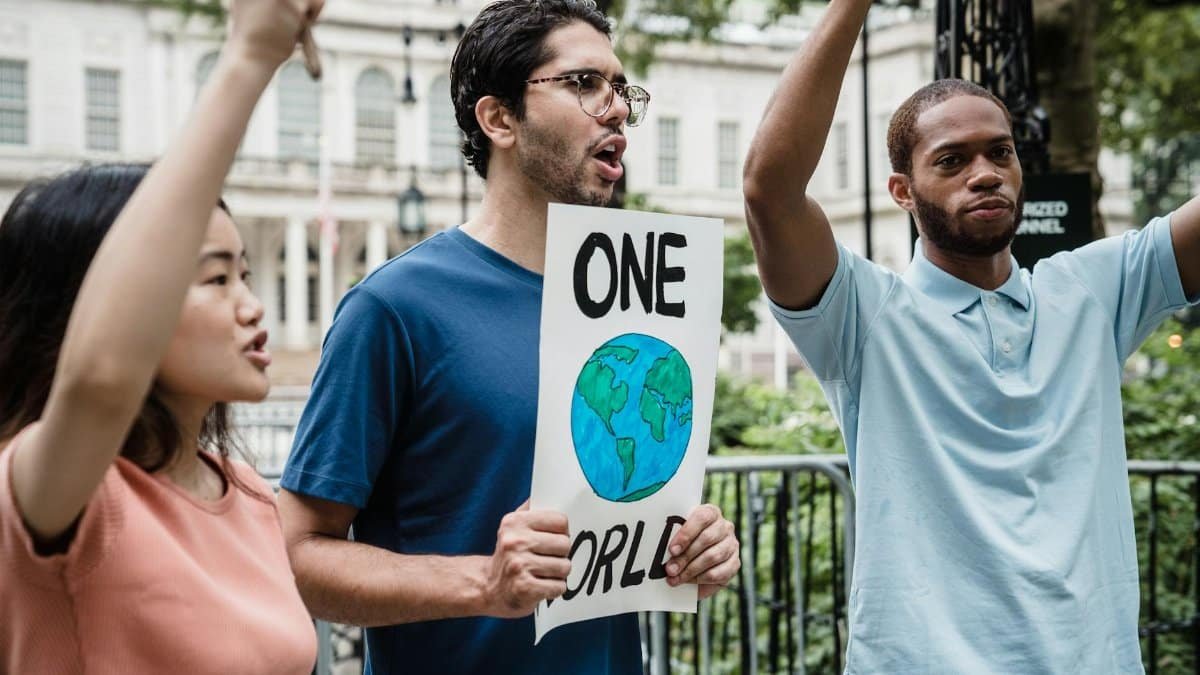 A diverse group of activists peacefully protest with signs for global unity.