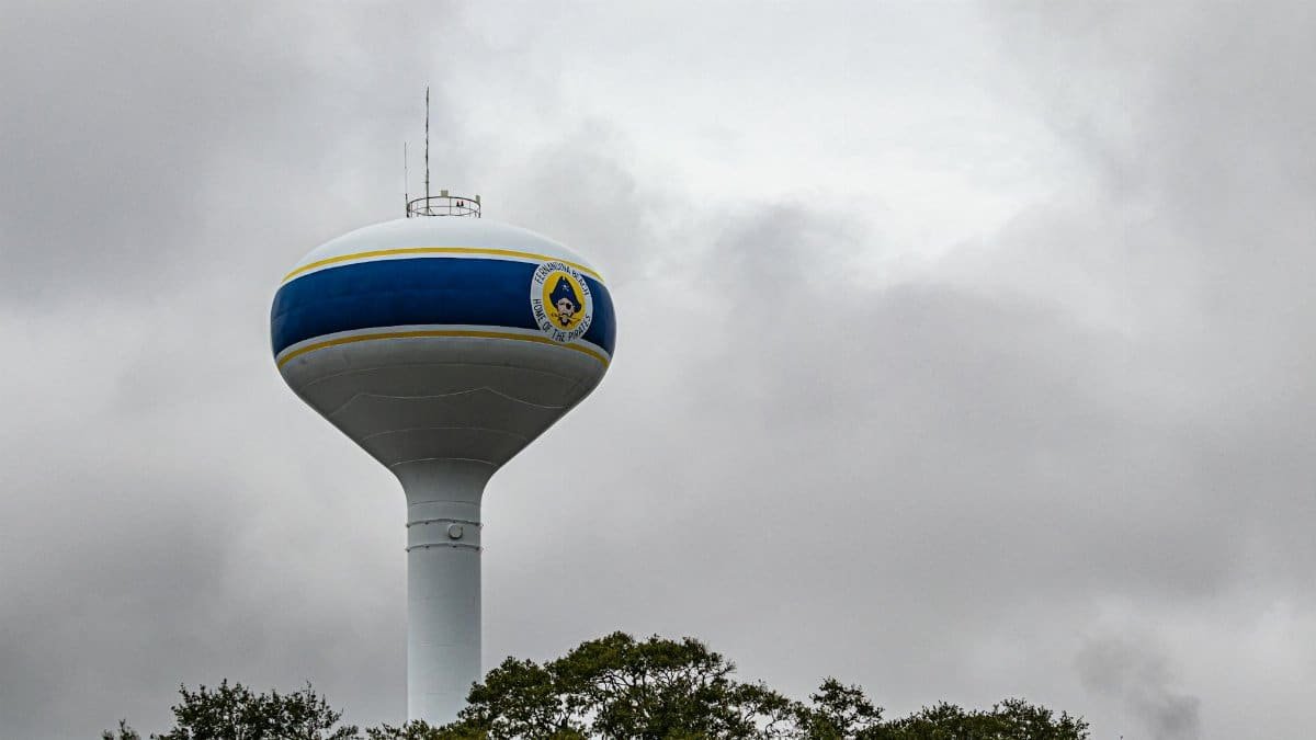A tall water tower in Fernandina Beach, Florida stands against a dramatic cloudy sky.