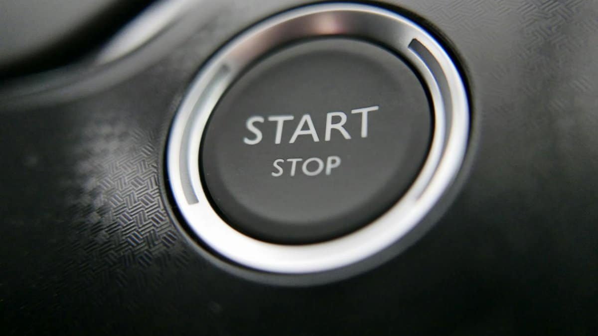 Close-up of a car's keyless ignition button with start and stop options.