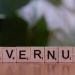 Close-up of wooden Scrabble tiles spelling 'UNVERNUFT' against a blurred background.