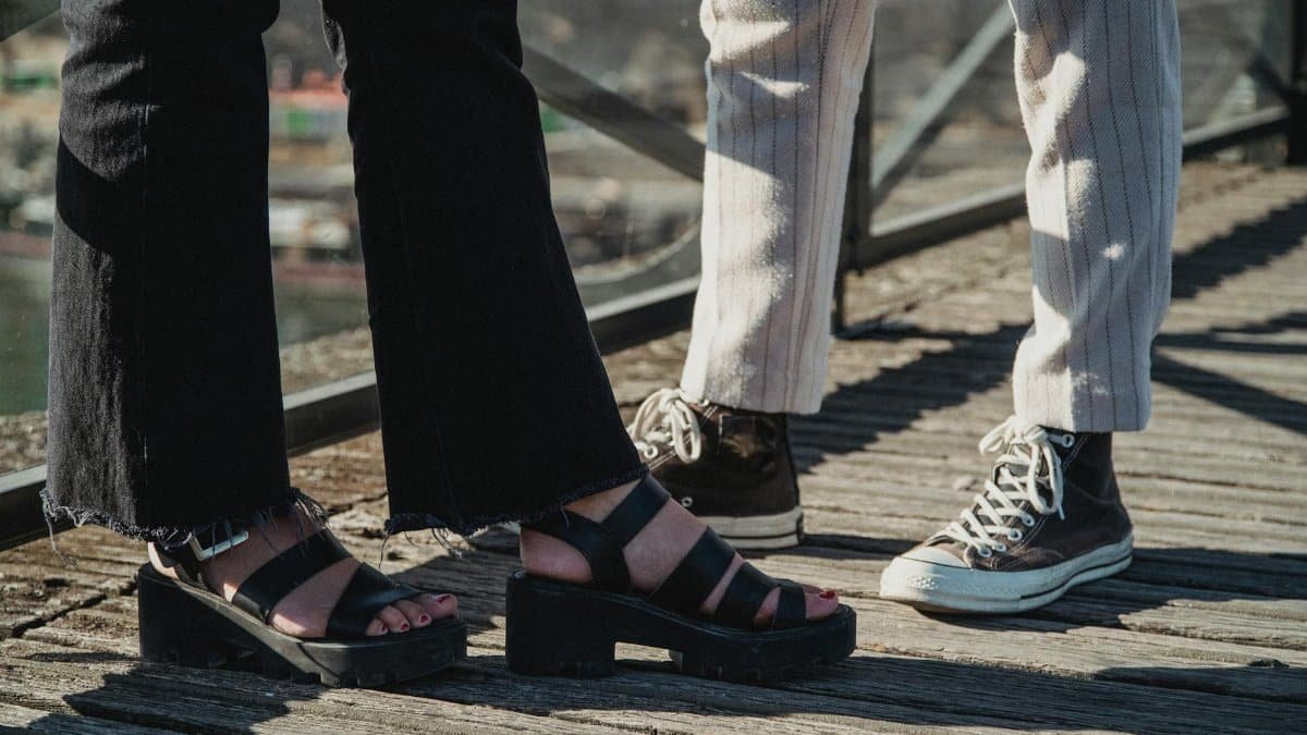 Stylish footwear on display outdoors, showcasing sandals and sneakers in a casual setting.