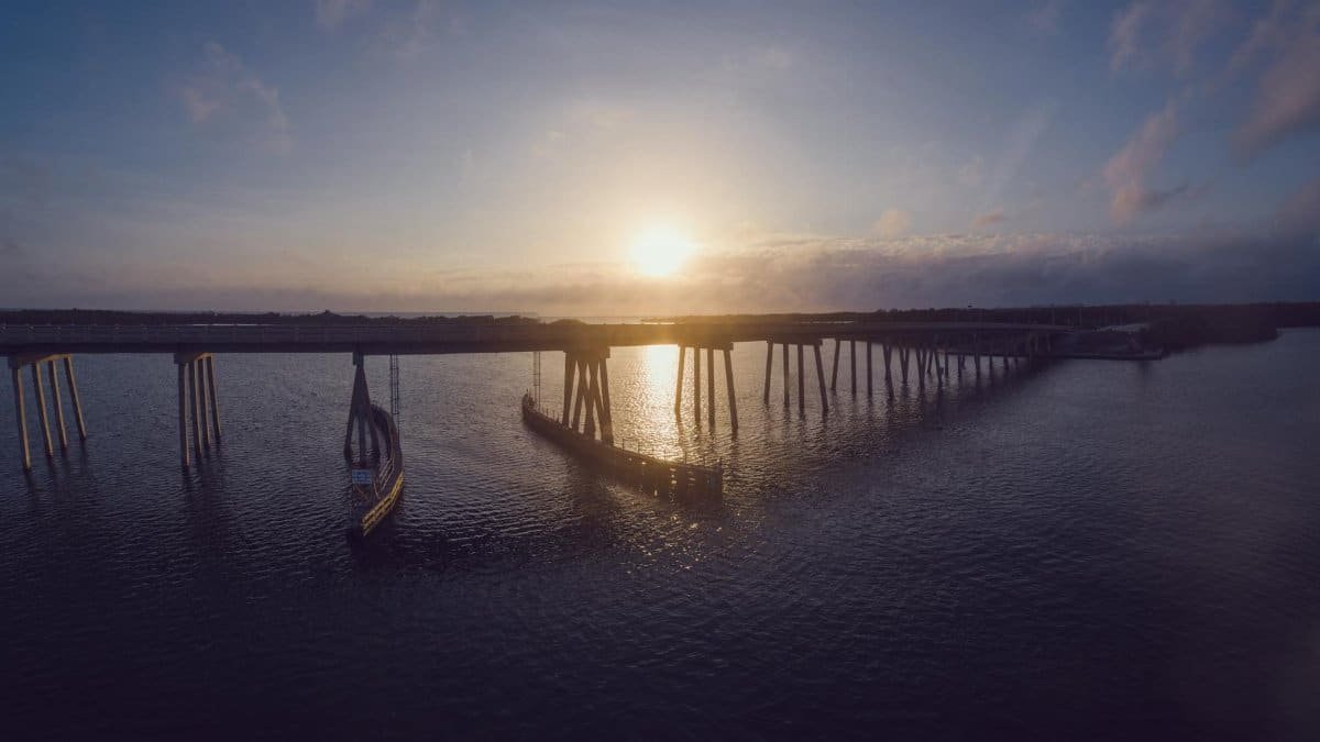 Breathtaking sunset over a bridge at Fort Myers Beach, reflecting in calm waters.