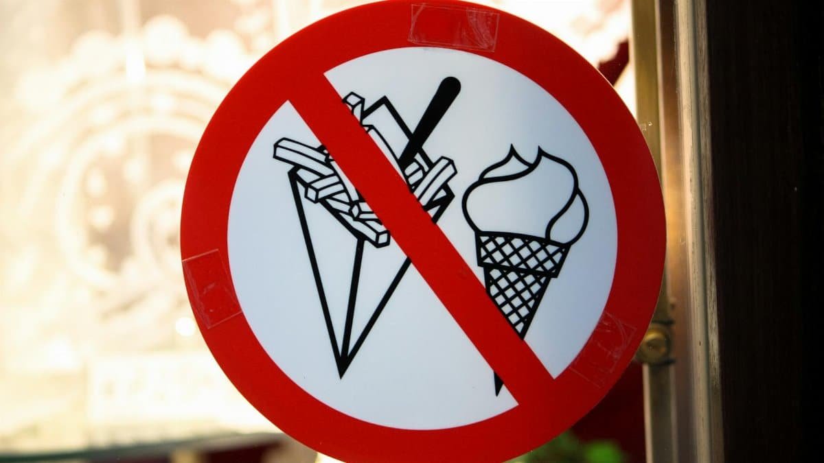 A sign in Brussels shows a prohibition on ice cream and fries in a restaurant setting.
