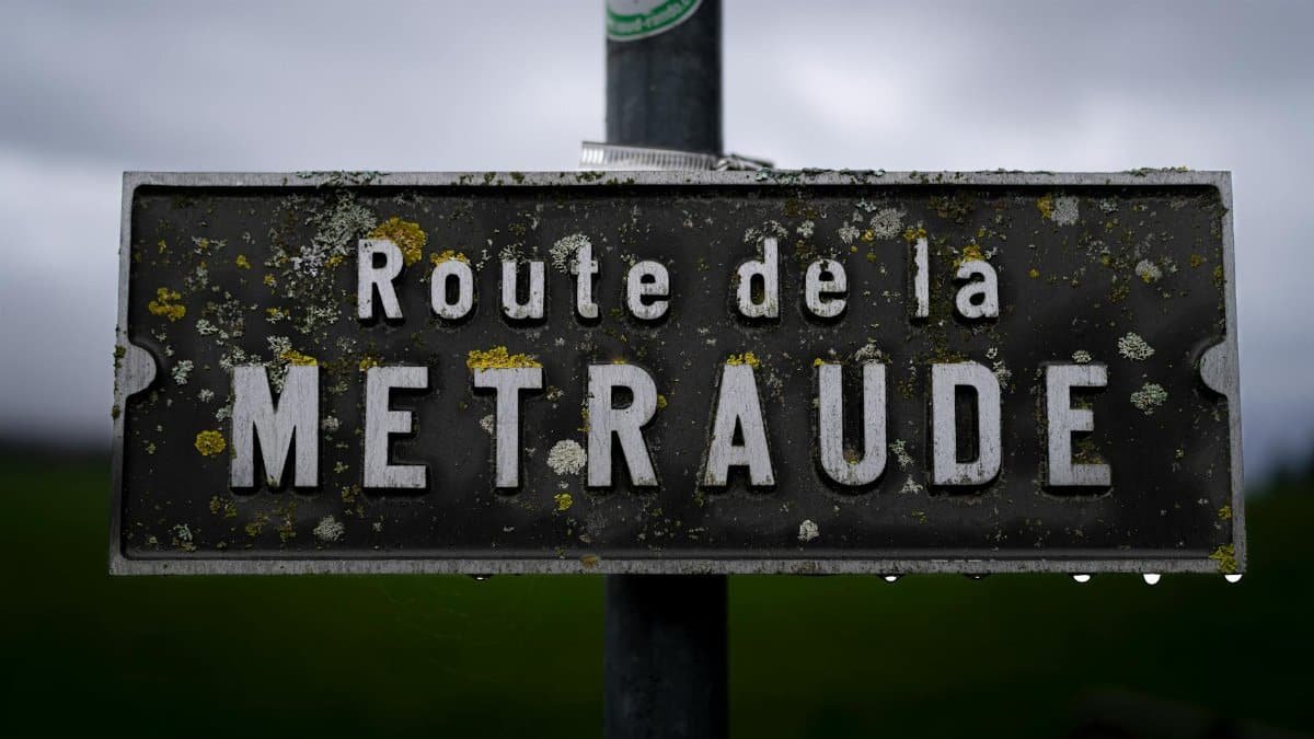 Close-up of a rustic road sign 'Route de la METRAUDE' in Lausanne, Switzerland.
