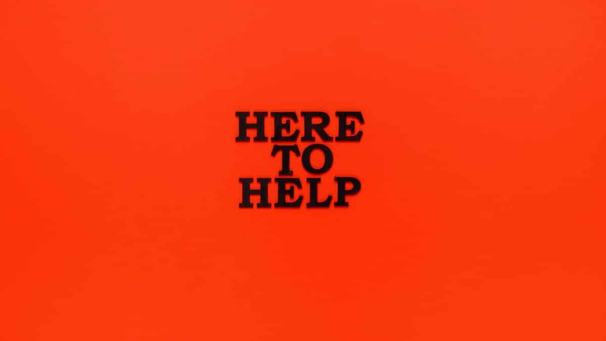 Bold 'Here to Help' motivational quote on a vibrant red background.