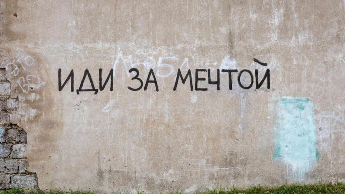 Graffiti with motivational text on an urban wall, embracing creativity and street art style.