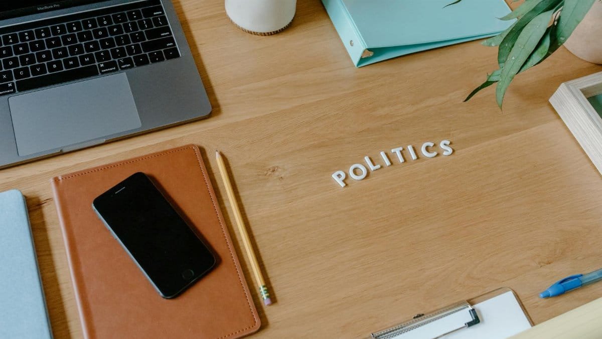 Neat office desk setup with laptop, smartphone, and political theme.