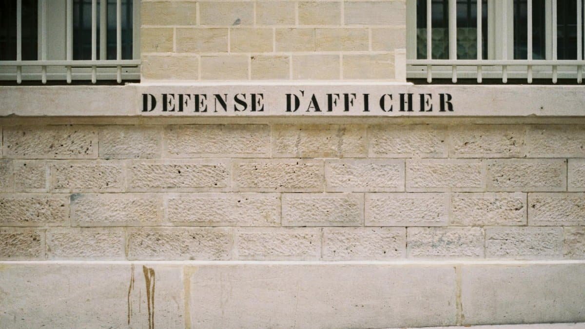 Wall in Paris displaying 'Défense d'afficher' in a minimalist setting. Perfect for design backgrounds.
