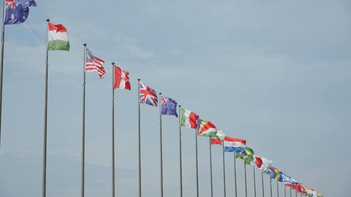A row of international flags on flagpoles symbolizing global unity and diplomacy.