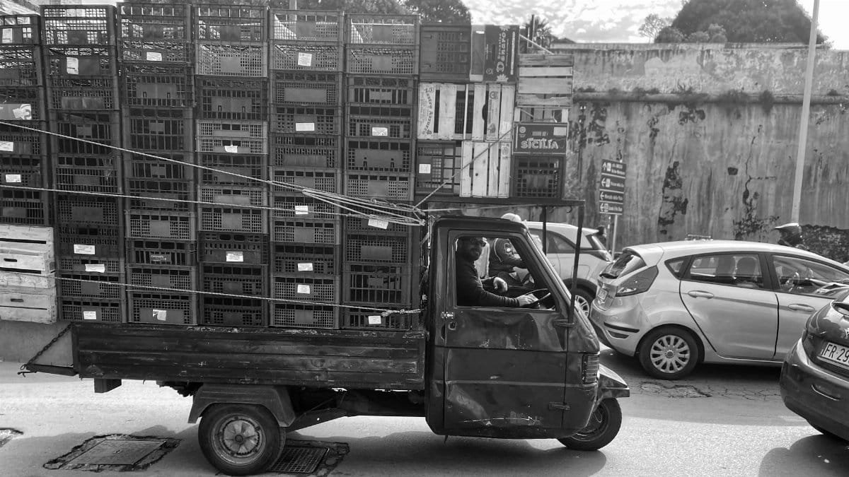 Black and white photo of a rustic truck in Palermo, Sicily, conveying local charm and everyday life.