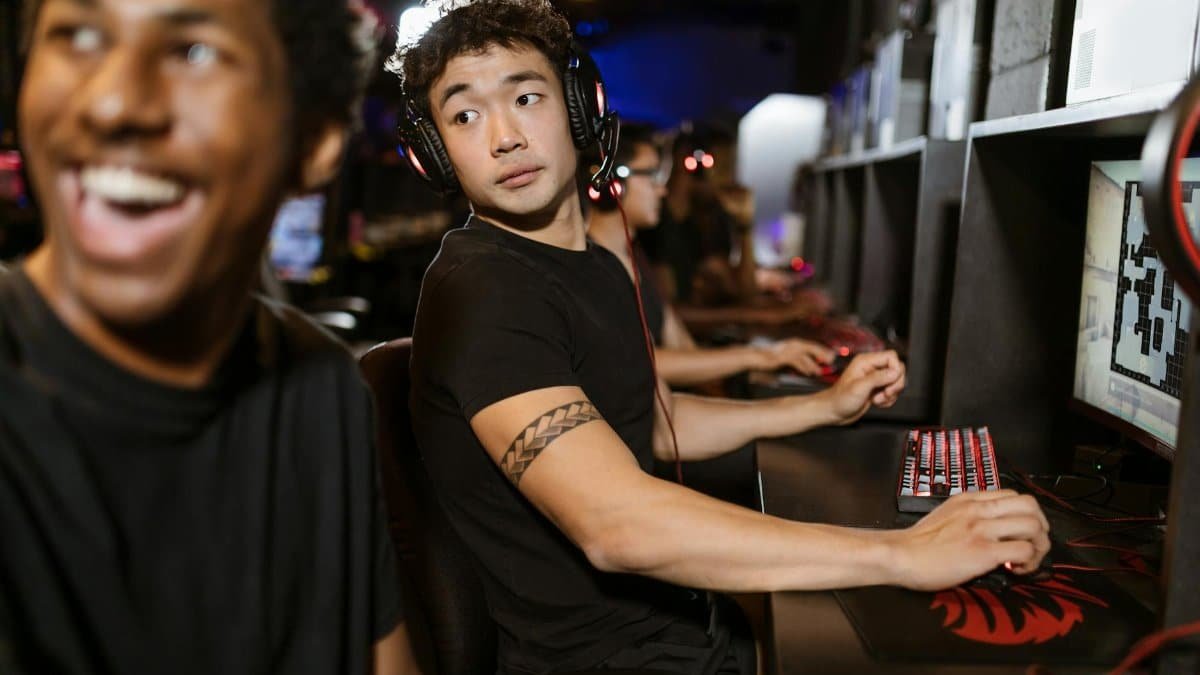 Young gamers engaged in a multiplayer session at an eSports arena with high-end gaming setups.