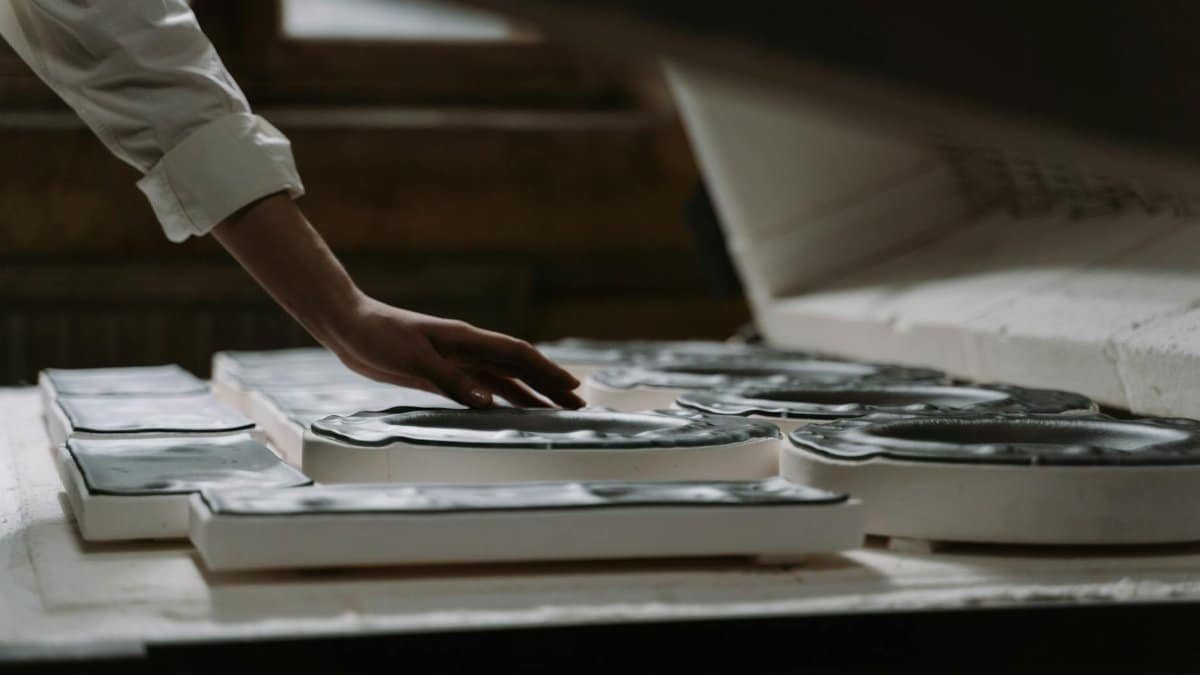 Close-up of artisan handcrafting glassware, highlighting creativity and craftsmanship in an indoor workshop.