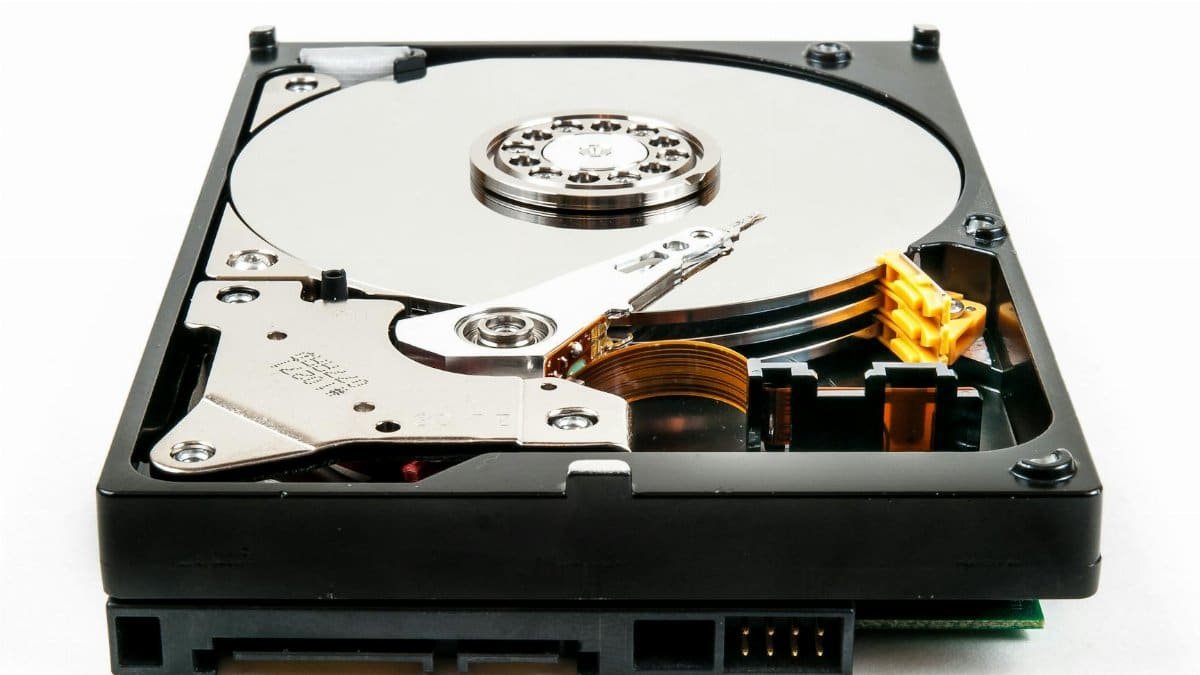 Detailed view of an open hard drive showcasing internal components against a white backdrop.