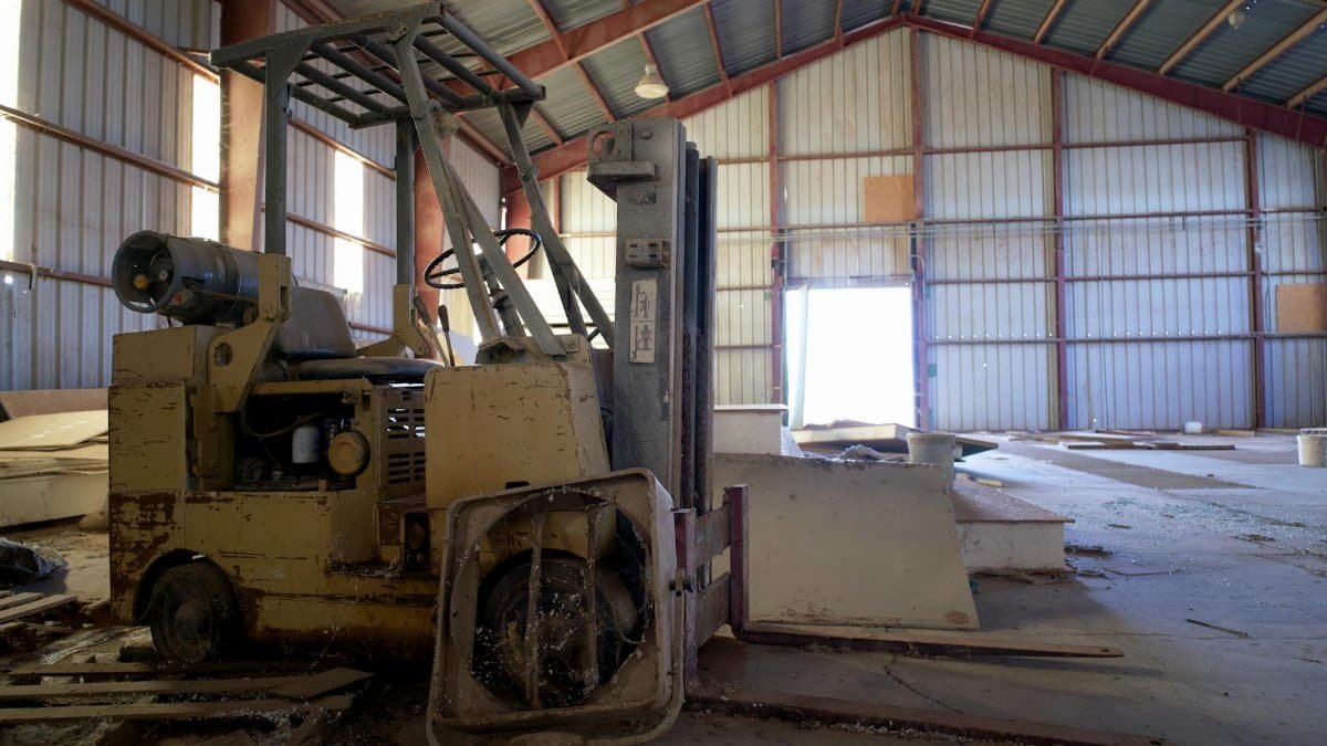 Interior view of an abandoned warehouse featuring a broken forklift in Arizona.