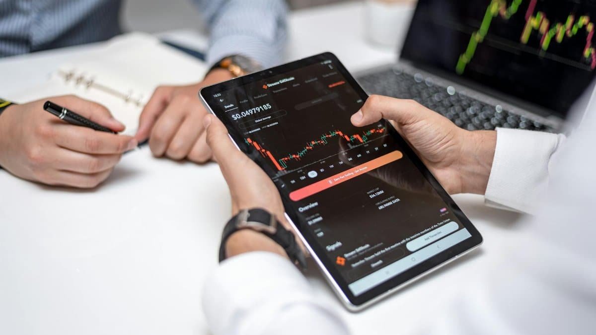 Professionals analyzing cryptocurrency data on a digital tablet during a business meeting.