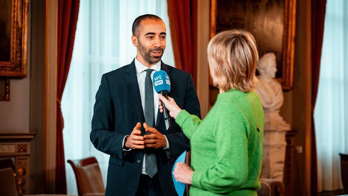 A journalist interviews a professional in a formal setting, highlighting media interaction.