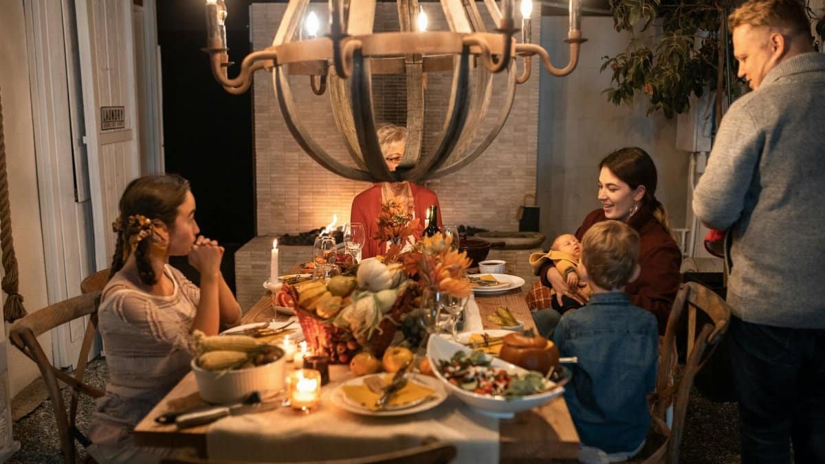 Warm family gathering around a festive Thanksgiving dinner table indoors with decorations.