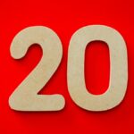 Wooden number 20 on vibrant red background, perfect for design themes.