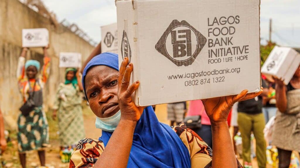 Community members engage in food distribution at Lagos Food Bank initiative event.