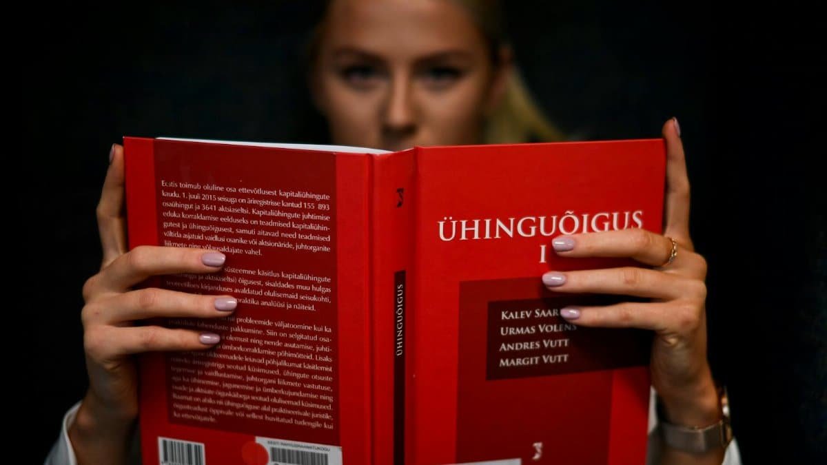 A law student intensely reading a legal textbook indoors in Tallinn, Estonia.