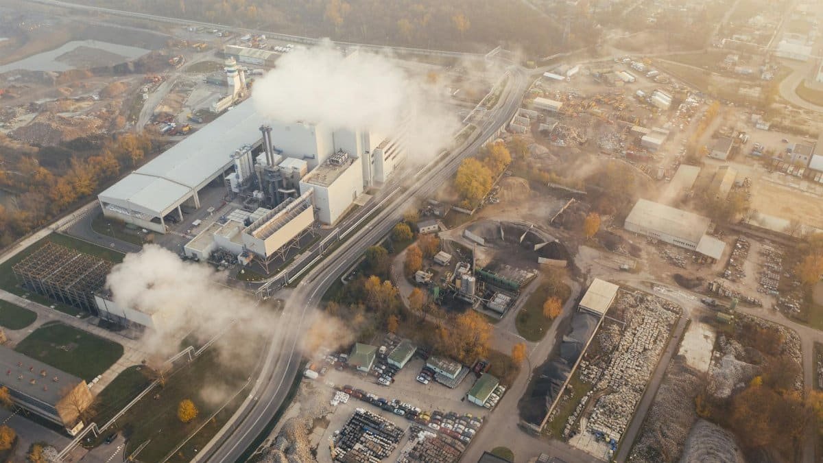 Aerial view showcasing an industrial complex in Poznań, Poland, emitting smoke and steam.