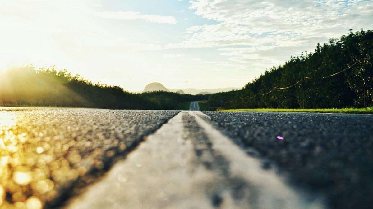Serene road stretching through lush landscape during sunset in Kangar, Malaysia.