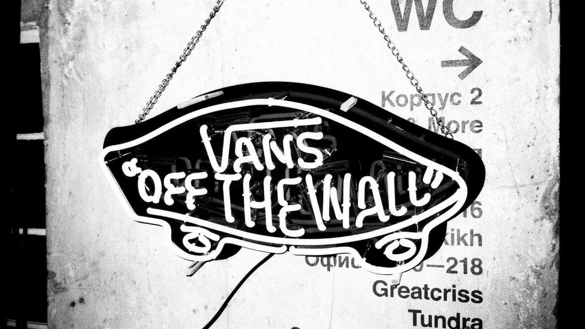 Artistic black and white image of a neon sign with vibrant text.