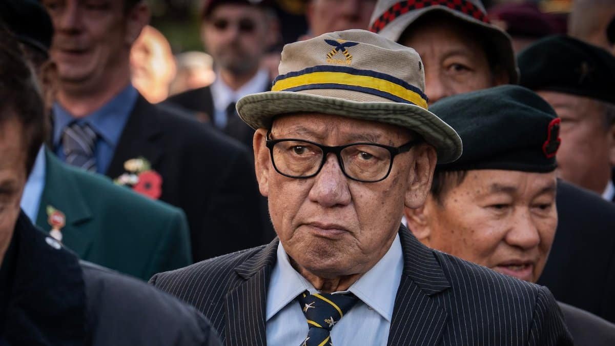 A gathering of veterans wearing hats and suits, honoring their service.