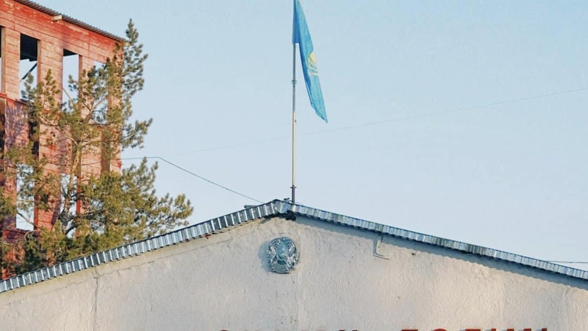 Fire station building in Konaev, Kazakhstan with the national flag on pole against a blue sky.