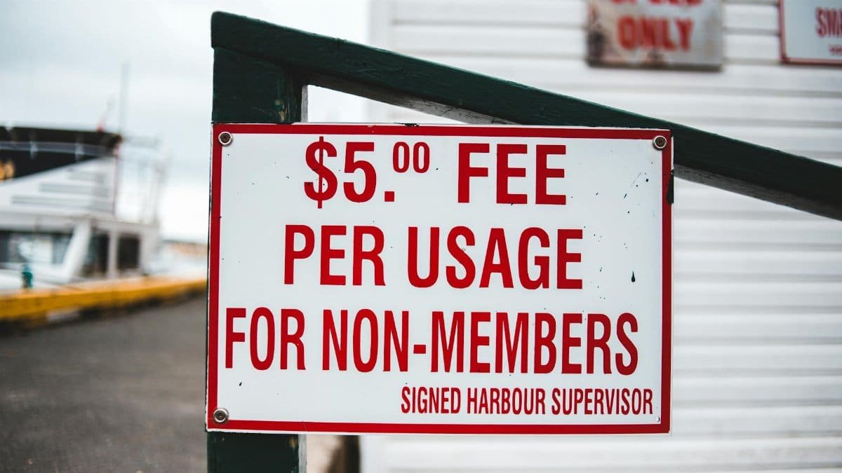 Close-up of a sign indicating a $5 usage fee for non-members at a harbor.