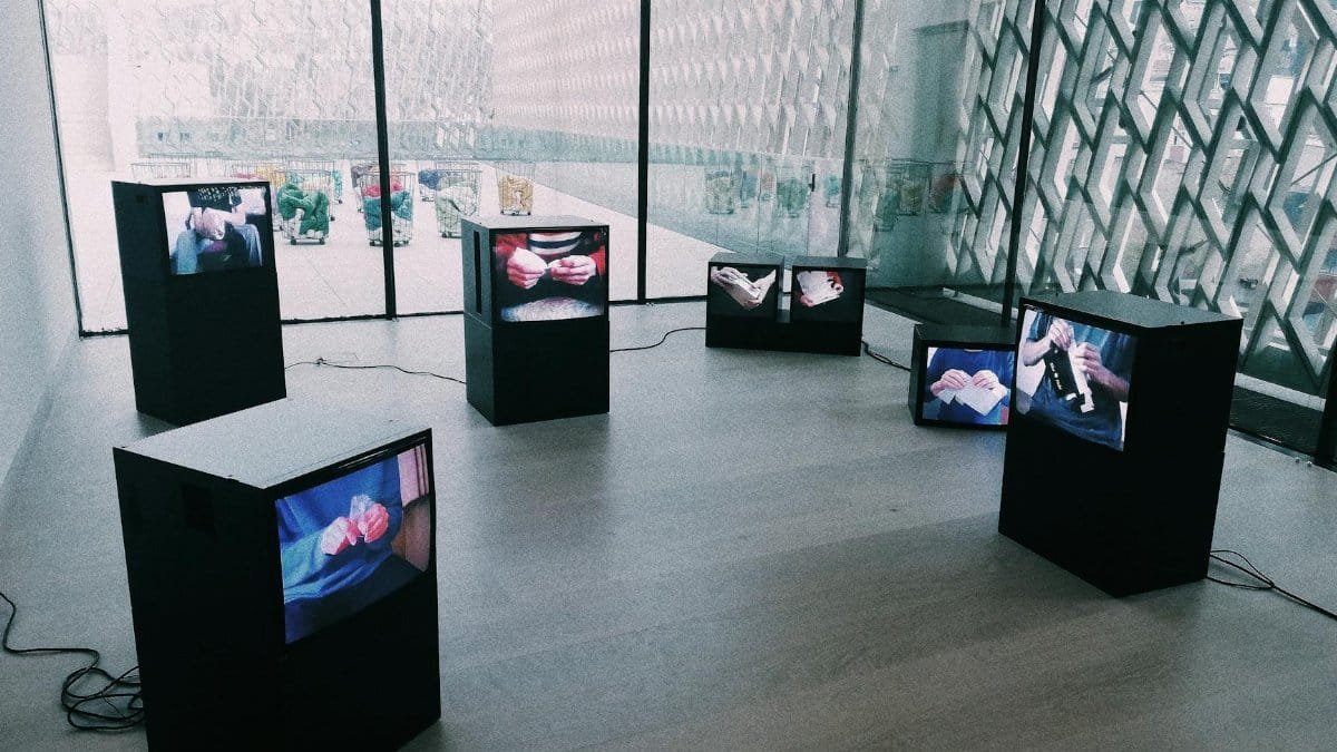 Explore a modern art exhibit with multiple screens displaying digital art in a sleek museum setting.