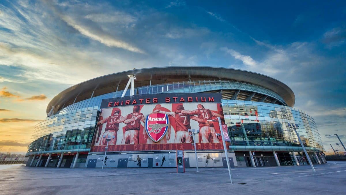 View of Emirates Stadium, home of Arsenal FC in London, showcasing modern architecture under a vibrant sky.