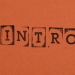 Close-up of the word INTRO stamped in black on an orange background, conveying a bold entrance.