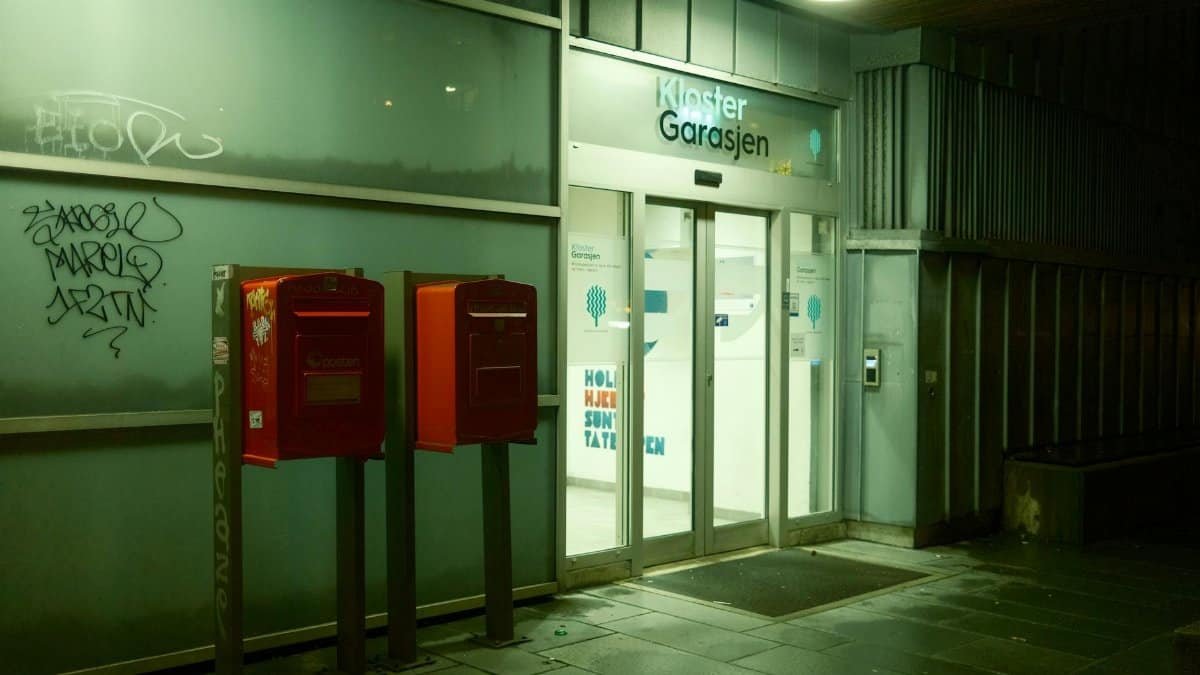 Night view of urban entrance with red mailboxes and modern architecture.