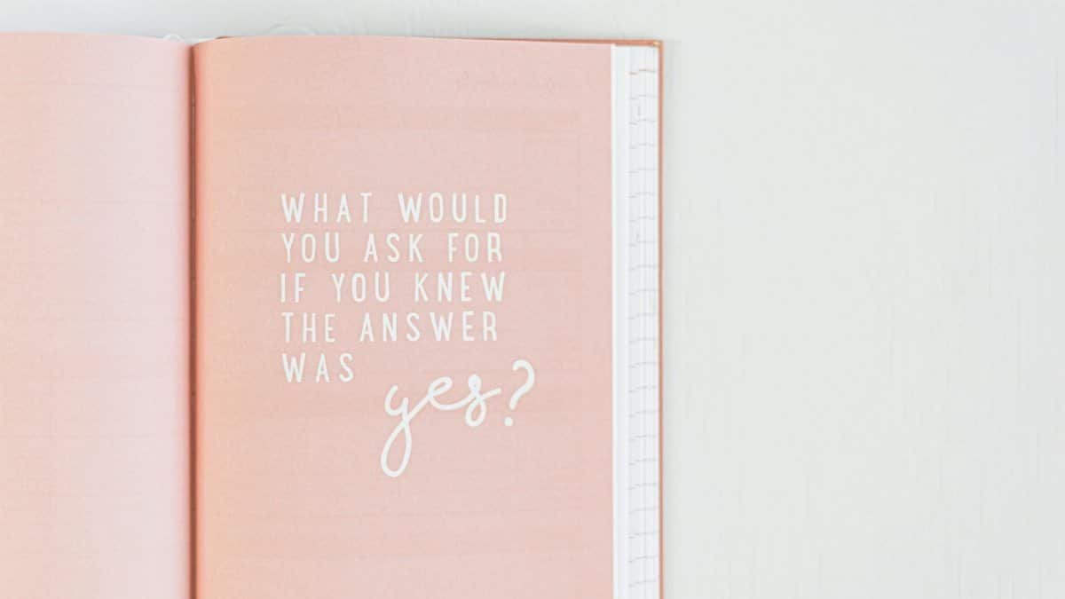 Open pink notebook with an inspirational quote in white text.