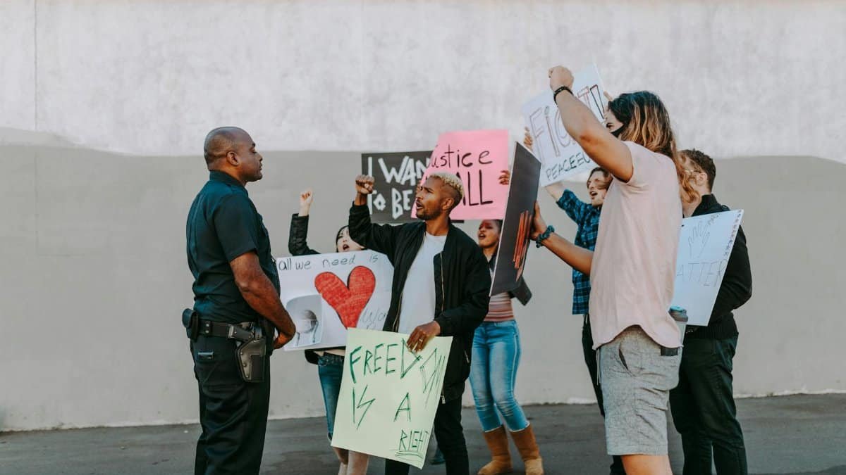 A group of diverse protesters holding signs during a peaceful demonstration outdoors.