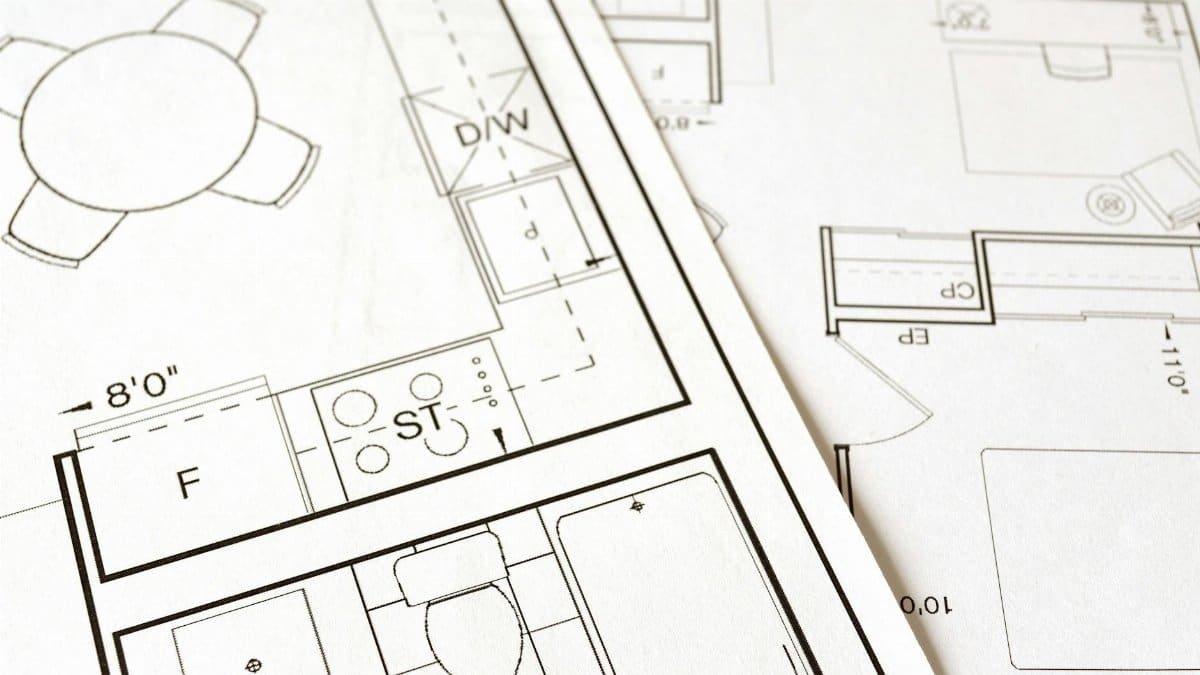 Close-up view of an architectural floor plan on paper showcasing detailed room layouts and measurements.
