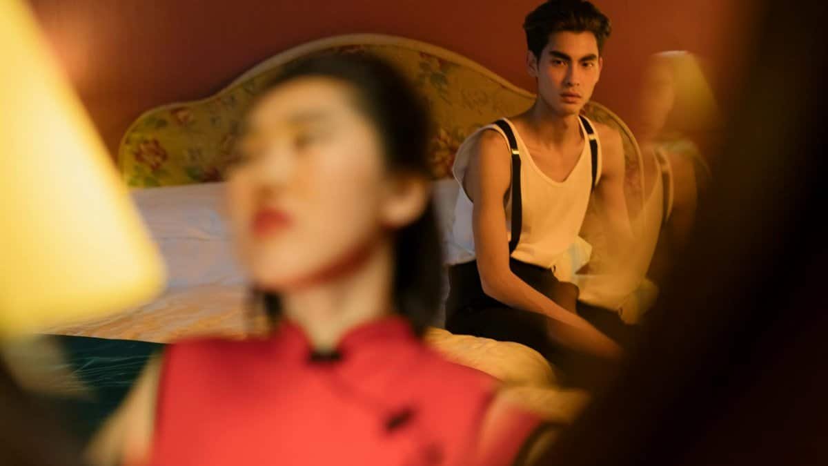 A couple's reflection in a mirror in a warmly lit hotel room, embodying intimacy and connection.