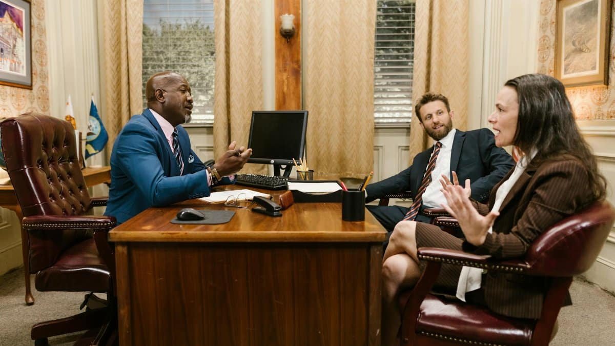 Three attorneys in a legal discussion at a well-appointed law office.