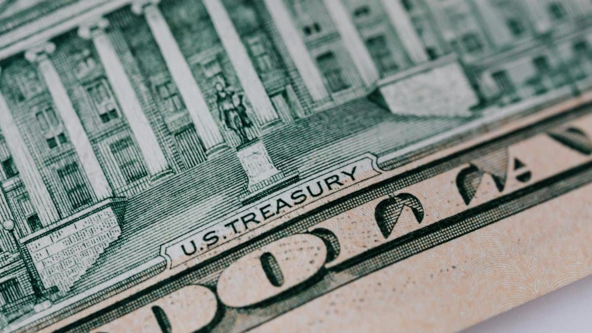 Detailed close-up of the U.S. Treasury text on a dollar bill, showcasing intricate design and financial symbolism.