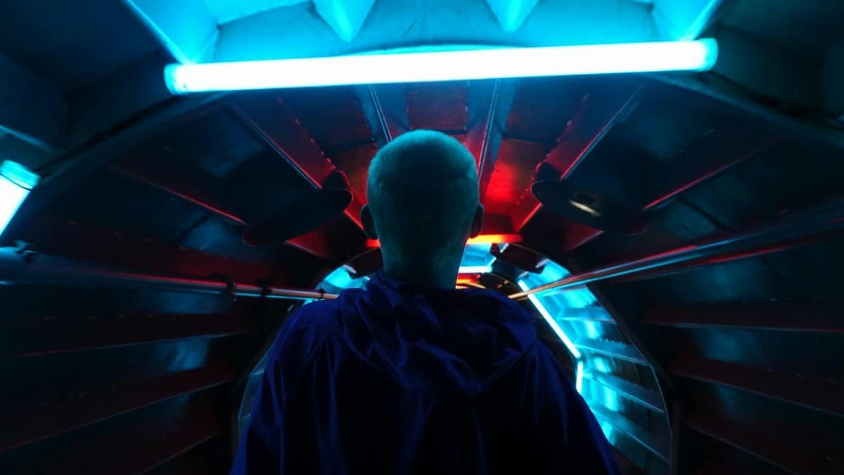 A person walks through a futuristic neon-lit tunnel in Brussels, Belgium.