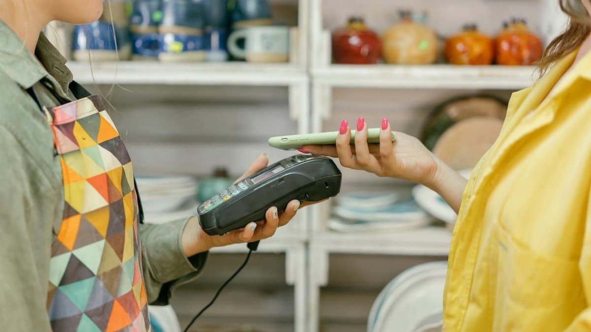 A customer makes a cashless payment using a smartphone in a retail store. Modern technology meets convenience.