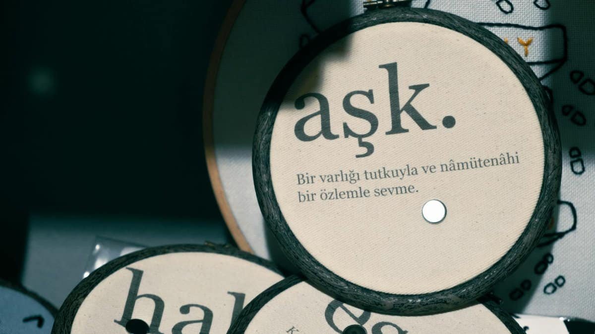 Detailed view of round decorations with Turkish embroidery text on fabric.