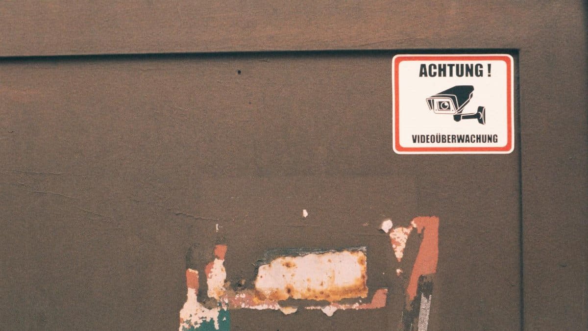 Rusty industrial door with a German surveillance warning sign