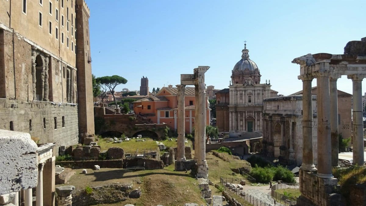 Explore the majestic ruins of the Roman Forum in Rome, showcasing historical architecture under a clear blue sky.