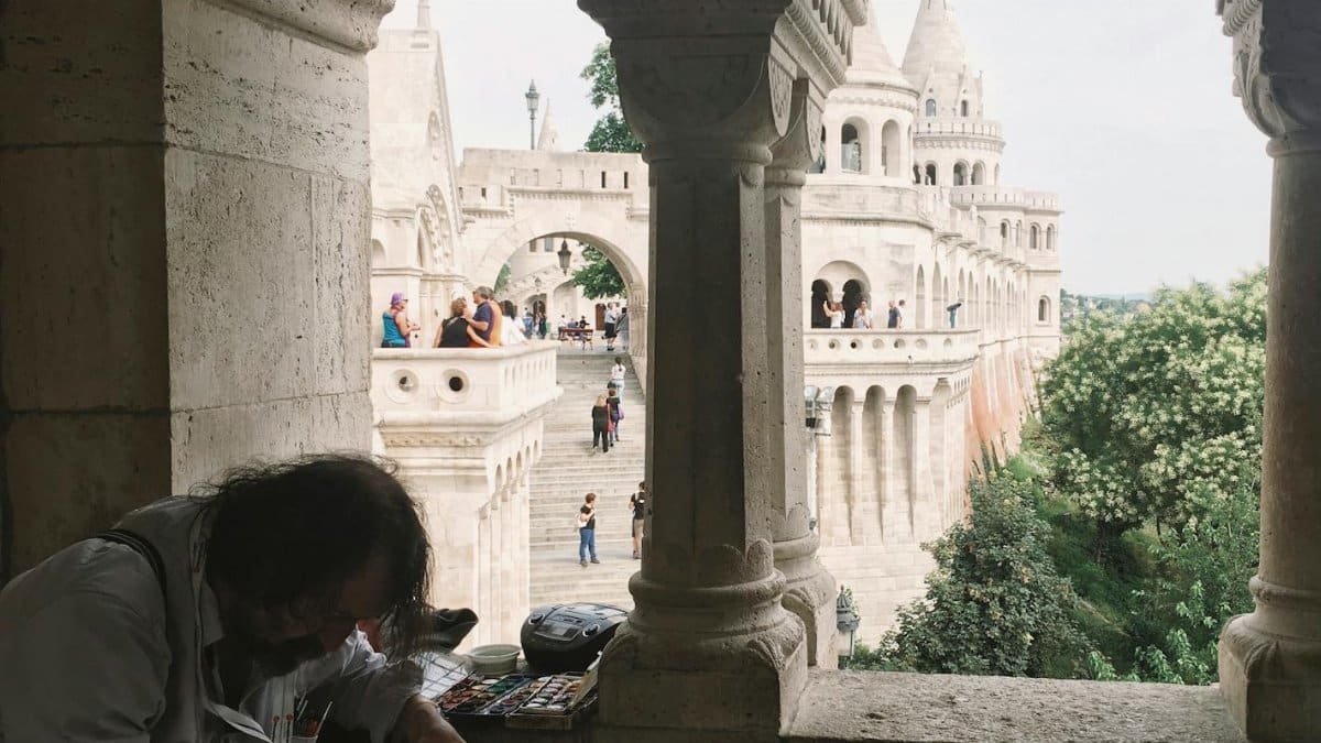 A local artist painting at Fisherman's Bastion, a popular architectural landmark in Budapest.