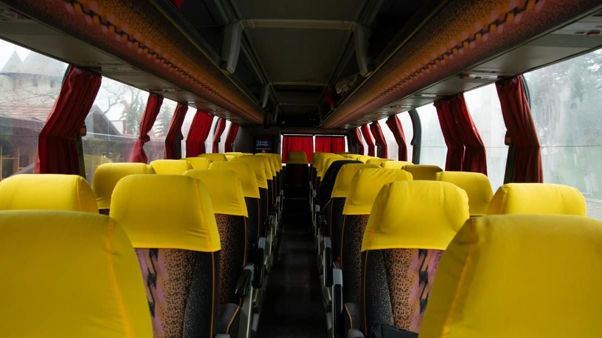 Spacious bus interior featuring bright yellow seats and red curtains, ideal for travel and transportation imagery.