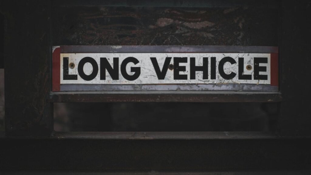Detailed close-up of a 'Long Vehicle' sign on a metal structure, showcasing industrial signage.