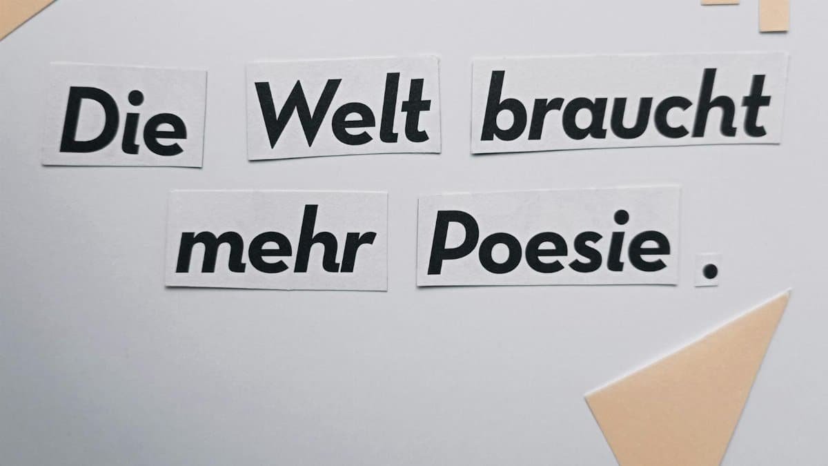 Cut-out text 'Die Welt braucht mehr Poesie' on a minimalist white background.